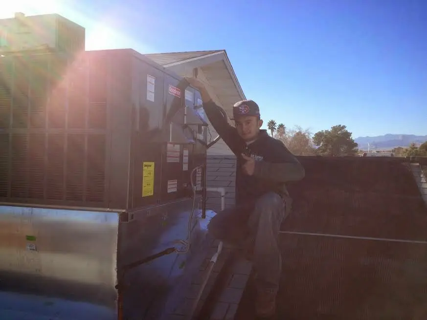 HVAC technician performing Heat Pump Repair on a rooftop unit in Stanwood